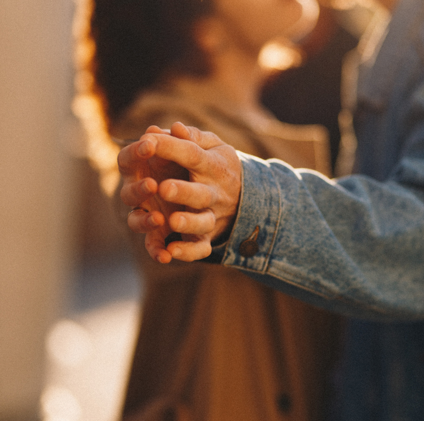 A close-up of a couple's interlocked hands, symbolizing connection and partnership.